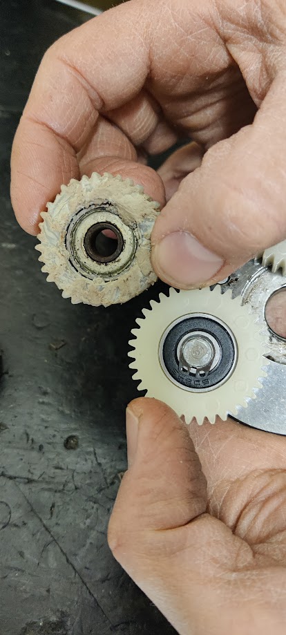 Tecnico Mobilitaslab che ispeziona gli ingranaggi planetari in nylon di un motore per bici elettrica durante una riparazione.