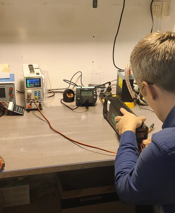 Banco da lavoro attrezzato con alimentatori e strumenti di misura per la diagnostica elettronica di e-bike.